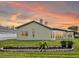 Back of house with nice landscaping, windows, and a peachy sky at 13102 Prestwick Dr, Riverview, FL 33579