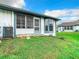 Backyard lawn with screened in porch featuring blue and white accents at 4844 Booth Bay Dr, New Port Richey, FL 34652