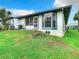 Backyard view with a well-maintained lawn, mature landscaping, and view of the building exterior at 4844 Booth Bay Dr, New Port Richey, FL 34652