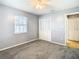 Bedroom with a large window, neutral carpet, closet, and soft gray walls at 4844 Booth Bay Dr, New Port Richey, FL 34652