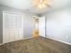 Cozy bedroom featuring plush carpeting, a ceiling fan, and a closet with white bi-fold doors at 4844 Booth Bay Dr, New Port Richey, FL 34652