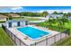 Community pool surrounded by lounge chairs, fenced for safety, and surrounded by lush lawn at 4844 Booth Bay Dr, New Port Richey, FL 34652