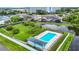 Aerial view of a community pool with lounge chairs and lush green landscaping near a pond at 4844 Booth Bay Dr, New Port Richey, FL 34652