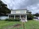 Two-story house with a front porch and overgrown yard at 1016 E Lake Ave, Tampa, FL 33605