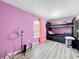 bedroom featuring a bunk bed and pink-painted walls, plus wood-look floors at 6343 Angus Valley Dr, Wesley Chapel, FL 33544