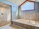 Relaxing bathroom featuring a soaking tub, walk-in shower, and tiled floors at 9375 Bearwalk Path, Weeki Wachee, FL 34613