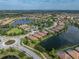 Aerial view of lakeside homes, community pool, and amenities offering a picturesque and desirable neighborhood setting at 5243 Esplanade Blvd, Bradenton, FL 34211