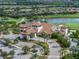 A stunning aerial view of a clubhouse with well manicured landscaping, palm trees and ample parking at 5243 Esplanade Blvd, Bradenton, FL 34211
