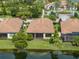 Aerial view of home with lush landscaping, lawn and water view at 5243 Esplanade Blvd, Bradenton, FL 34211