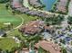 Aerial view featuring a clubhouse, parking, golf course, ponds, and beautiful neighborhood at 5243 Esplanade Blvd, Bradenton, FL 34211