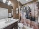Cozy bathroom with stylish shower curtain, dark wood cabinet and white sink at 5243 Esplanade Blvd, Bradenton, FL 34211