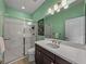 Bright bathroom featuring a glass-enclosed shower, dark vanity and a large mirror at 5243 Esplanade Blvd, Bradenton, FL 34211