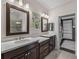 Bright bathroom featuring dual sinks with dark wood cabinets, quartz countertop, and walk-in closet at 5243 Esplanade Blvd, Bradenton, FL 34211