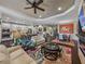 Bright open living area featuring a modern kitchen, comfortable seating, and a dining space with orange accent wall at 5243 Esplanade Blvd, Bradenton, FL 34211