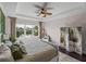 Bright main bedroom features a trey ceiling, ceiling fan, and views of the backyard pond at 5243 Esplanade Blvd, Bradenton, FL 34211