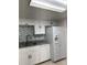 Modern kitchen with stainless steel sink, white cabinets, and gray backsplash at 7522 Gallineta Ct # 7522, Tampa, FL 33615