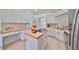 White kitchen with island and stainless steel appliances at 902 Mcdaniel St # 1, Sun City Center, FL 33573