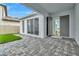 Covered patio with gray pavers, gray doors, and a grassy backyard at 10520 Purple Thistle Way, San Antonio, FL 33576