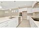 Spacious kitchen island with white cabinets, quartz countertops and stainless steel sink at 10520 Purple Thistle Way, San Antonio, FL 33576