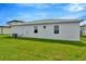 Rear view of a light gray house with a grassy lawn at 10520 Purple Thistle Way, San Antonio, FL 33576