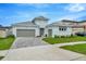 Two-story light blue house with gray double garage and paver driveway at 10520 Purple Thistle Way, San Antonio, FL 33576