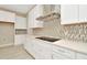 Modern kitchen with white cabinets, quartz countertops, and stainless steel appliances at 10520 Purple Thistle Way, San Antonio, FL 33576