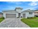 Two-story light blue house with gray double garage and a paved driveway at 10520 Purple Thistle Way, San Antonio, FL 33576