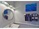 Small bathroom with white sink, vanity, and round mirror at 4790 Snook Se Dr, St Petersburg, FL 33705