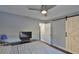 Bedroom with barn door, ceiling fan, and view of hallway at 4790 Snook Se Dr, St Petersburg, FL 33705