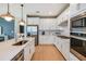 Modern kitchen with white cabinets, quartz countertops, and stainless steel appliances at 3614 Maple Bay Ln, Land O Lakes, FL 34638