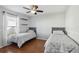 Two twin beds in a well-lit bedroom with wood floors at 7720 Rathdown Ln, Wesley Chapel, FL 33545