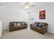 Bonus room with two sofas, ceiling fan, and large window at 7720 Rathdown Ln, Wesley Chapel, FL 33545