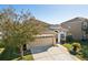 Tan two-story house with a two-car garage and manicured lawn at 7720 Rathdown Ln, Wesley Chapel, FL 33545