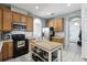 Well-equipped kitchen featuring wood cabinets and an island at 7720 Rathdown Ln, Wesley Chapel, FL 33545
