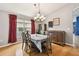 Dining room with hardwood floors, table, and red curtains at 6843 Runner Oak Dr, Wesley Chapel, FL 33545