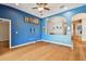 Living room with blue walls, wood floors and ceiling fan at 6843 Runner Oak Dr, Wesley Chapel, FL 33545
