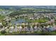 Aerial view of a neighborhood with houses and a central lake at 6843 Runner Oak Dr, Wesley Chapel, FL 33545