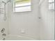 White tiled bathroom with a tub and shower at 6843 Runner Oak Dr, Wesley Chapel, FL 33545