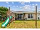 Backyard view of home and playset at 6843 Runner Oak Dr, Wesley Chapel, FL 33545