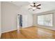 Bedroom with hardwood floors, ceiling fan, and access to patio at 6843 Runner Oak Dr, Wesley Chapel, FL 33545