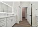 Bathroom with white vanity, walk-in closet access, and wood-look floors at 6439 Taylor Ct, New Port Richey, FL 34653