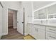 Bathroom with white vanity, walk-in closet access, and wood-look floors at 6439 Taylor Ct, New Port Richey, FL 34653
