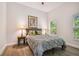 Bright bedroom with gray bedding, wood floors, and large windows at 6439 Taylor Ct, New Port Richey, FL 34653