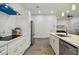 Modern kitchen with white cabinets, stainless steel appliances and blue vent hood at 6439 Taylor Ct, New Port Richey, FL 34653