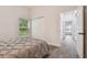 Bedroom with gray bedding, wood floors, and access to hallway at 6439 Taylor Ct, New Port Richey, FL 34653