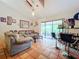 Living room with comfy sofa, glass coffee table, and access to patio at 5001 80Th Avenue E Cir, Sarasota, FL 34243