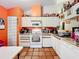 Kitchen with white cabinets, orange walls, and full-size appliances at 5001 80Th Avenue E Cir, Sarasota, FL 34243