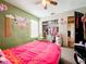 Bedroom with pink bedding, a closet and green walls at 5001 80Th Avenue E Cir, Sarasota, FL 34243