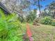 Fenced backyard with brick path, tropical plants and trees at 5001 80Th Avenue E Cir, Sarasota, FL 34243