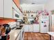 Kitchen with white cabinets, orange walls, and full-size appliances at 5001 80Th Avenue E Cir, Sarasota, FL 34243